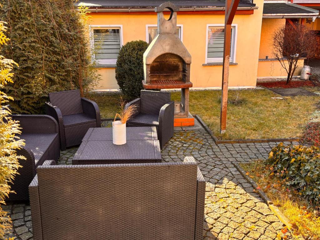 a patio with two chairs and a table with a fireplace at Ferienwohnung Am Schleizer Dreieck in Schleiz