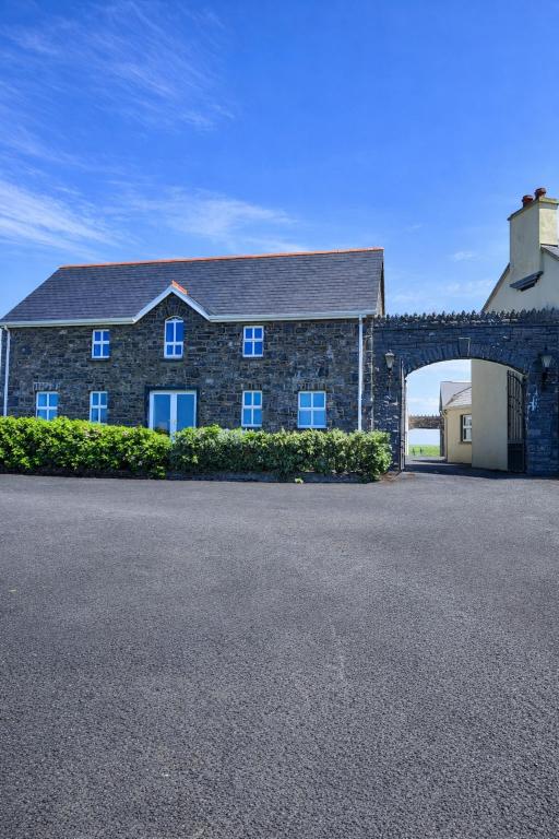 a large brick building with a large garage at Aran View Holiday Homes Doolin - The Atlantic Stone House - Ocean Views in Doolin