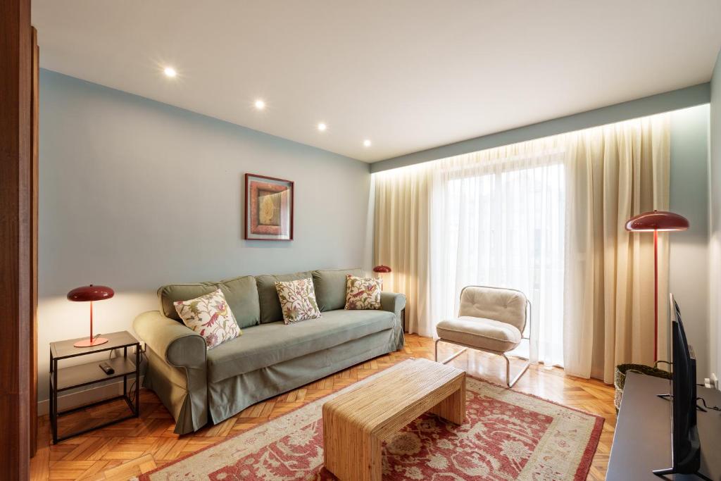 a living room with a couch and a table at VIVA Serpa Pinto Serviced Apartments in Porto