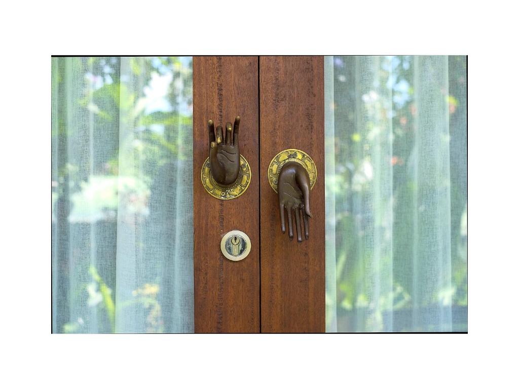 a wooden door with a pair of gloves on it at Narendra Guest House in Ubud