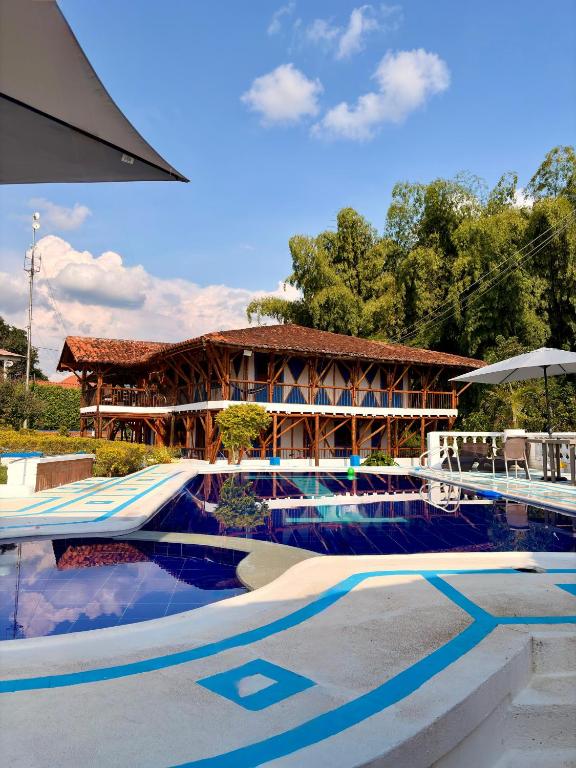 a resort with a swimming pool and a building at La orquídea campestre in Montenegro