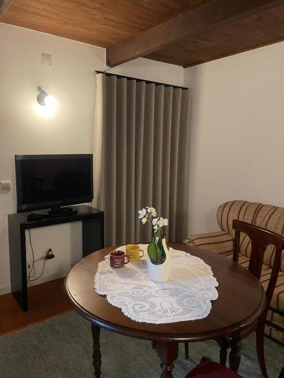 a living room with a table with flowers on it at Casa do Fundão in Paredes