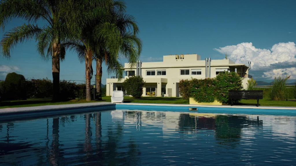 ein Haus mit einem Swimmingpool vor einem Gebäude in der Unterkunft LS Apart Hotel in Martin Miguel de Güemes International Airport