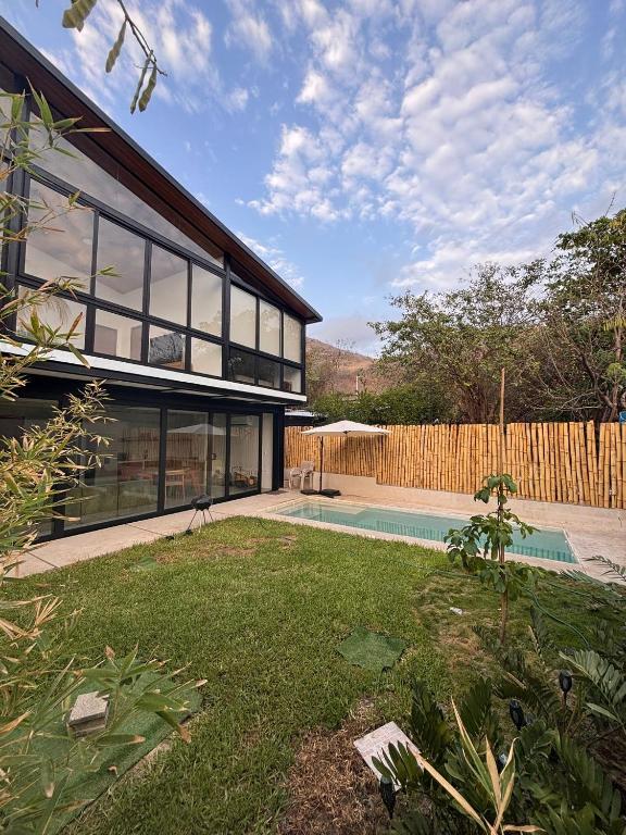 a house with a swimming pool and a fence at Jungle surf Villa in El Zonte