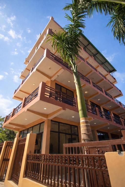 a building with a palm tree in front of it at Moon and Root in Narendranagar