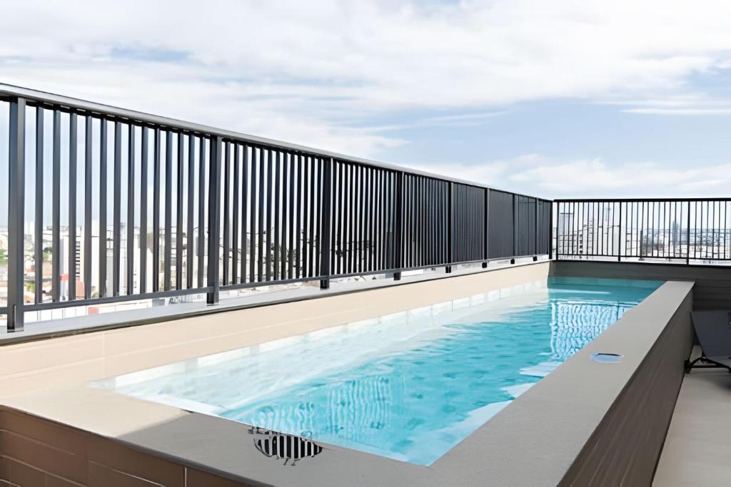 a swimming pool on the balcony of a building at Studios ZP in Uberlândia