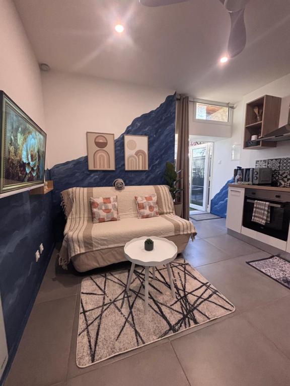 a room with a bed and a table in it at Studio Bleu tout équipé au calme proche des commerces in Briord