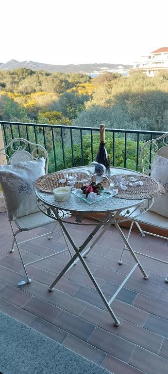 a table and chairs on a balcony with a bottle of wine at Gina&Gian Guest House in Olbia