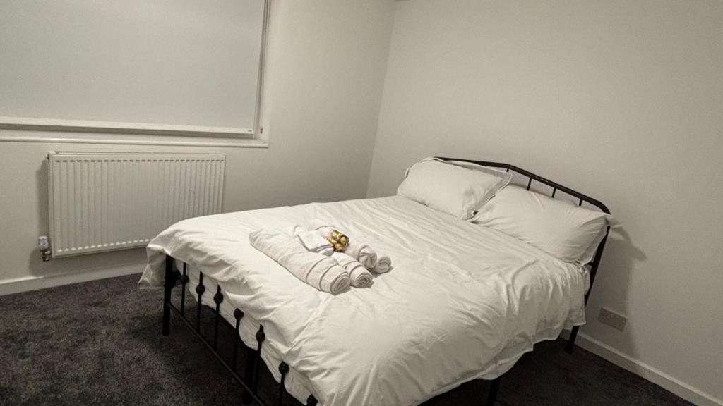ein Schlafzimmer mit einem Bett, auf dem ein Teddybär liegt in der Unterkunft SAMAz in Manchester