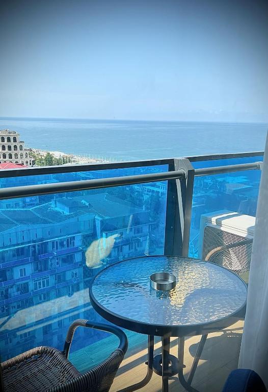 a table on a balcony with a view of the ocean at best VIP HOTEL panorama suites IN batumi R in Batumi