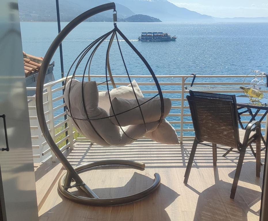 a swing and a chair on a balcony with the ocean at Pearl's apartments Old town Ohrid in Ohrid