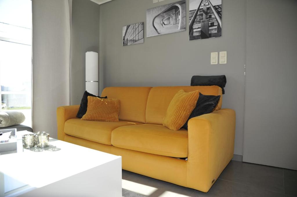 a living room with a yellow couch and a table at Le Clos Sigebert in Libramont