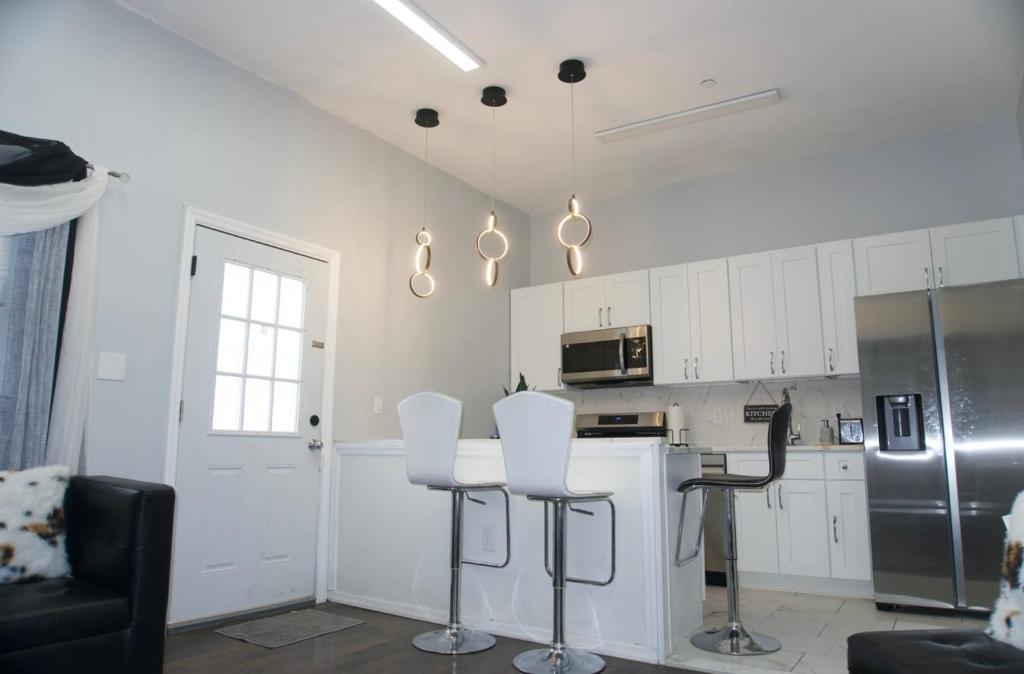a kitchen with white cabinets and a table and chairs at Basemant private room 21 in Guttenberg