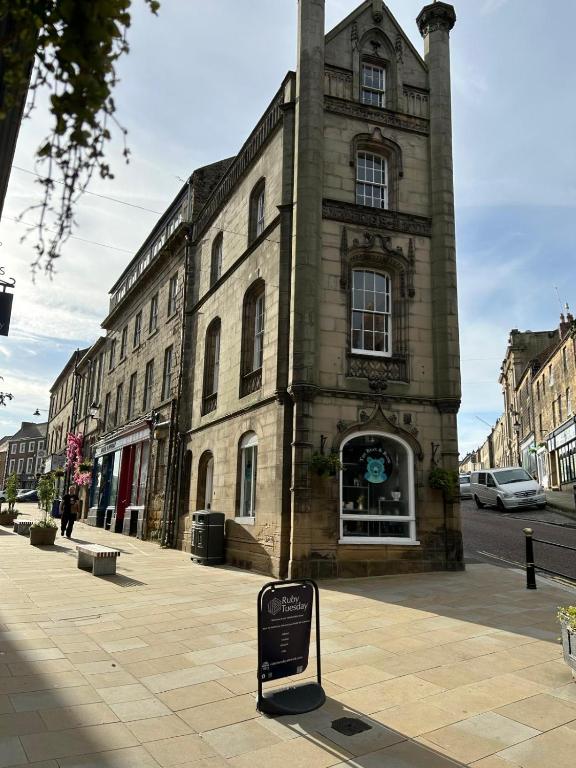 a large brick building with a sign in front of it at The Counting House in Alnwick