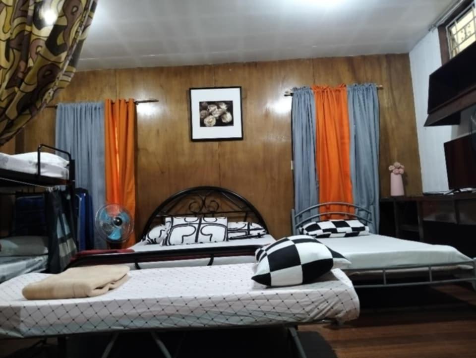 a bedroom with two beds in a room at Jenny's transient house in Baguio
