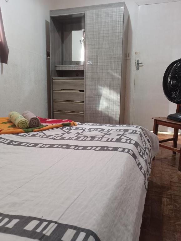 a bedroom with a bed and a dresser and a closet at Hotel quarto 01 in Montes Claros