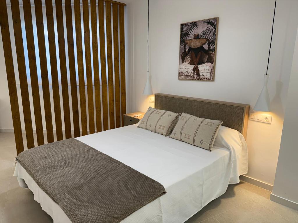 a bedroom with a large white bed with two pillows at Apartamentos San Antonio - GrupoAMI in Ontinyent