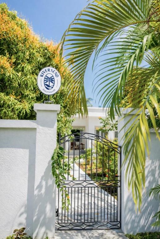a gate to a building with a sign on it at Rivers End Guesthouse in Hope Bay