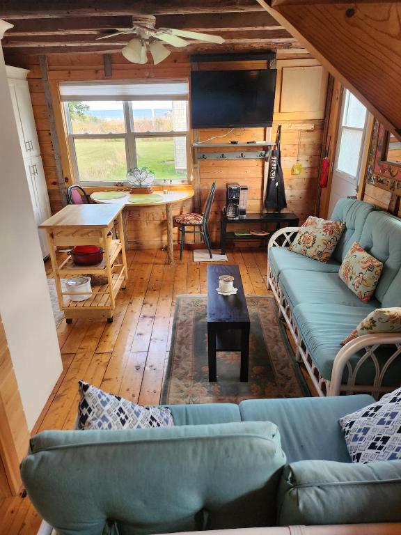 a living room with couches and a table at Cable Head Oceanview Casita in Saint Peters
