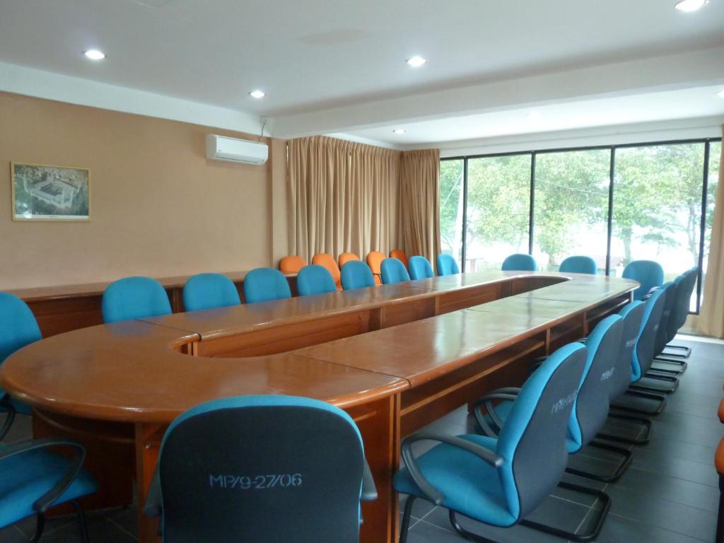 a conference room with a long table and blue chairs at Cempaka Beach Resort in Kuantan