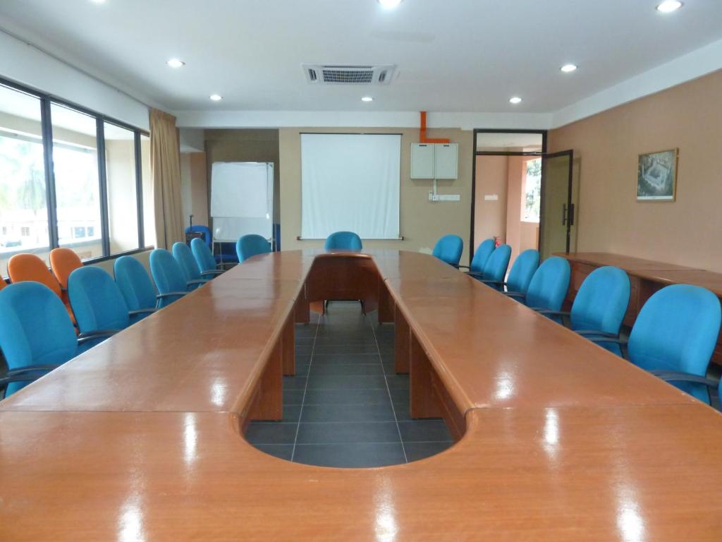 a large conference room with a long table and blue chairs at Cempaka Beach Resort in Kuantan