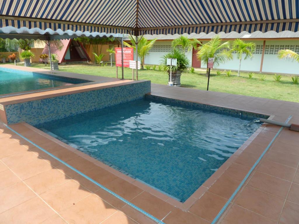 a swimming pool in front of a house at Cempaka Beach Resort in Kuantan