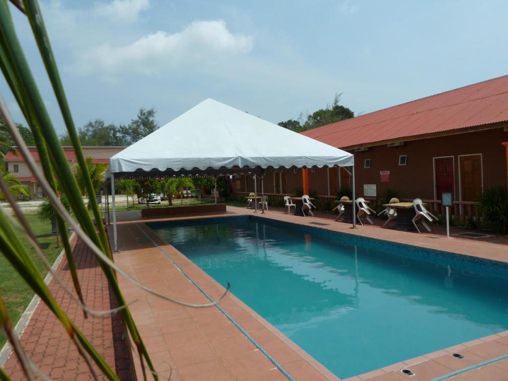 a large swimming pool with a white tent around it at Cempaka Beach Resort in Kuantan