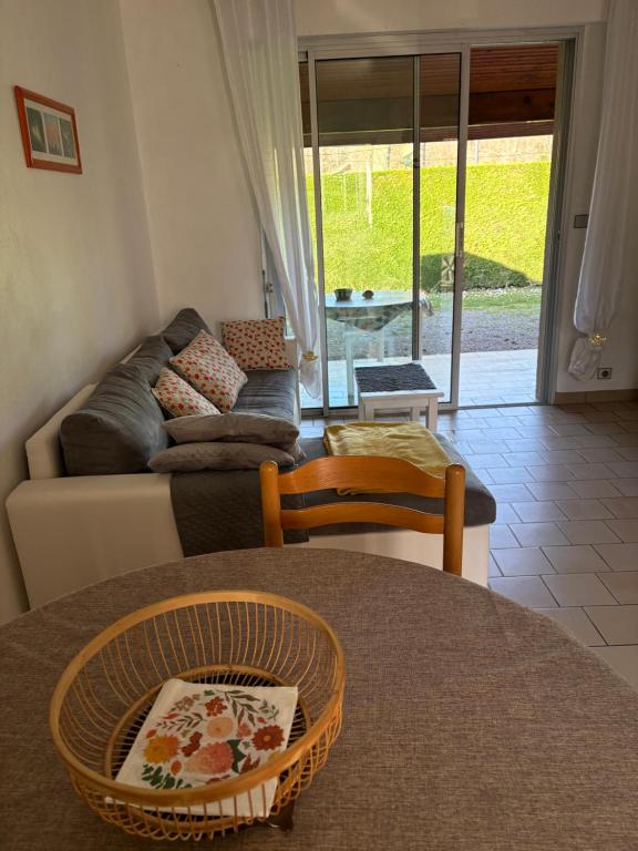 a living room with a couch and a table at Albizias 3 in Eugénie-les-Bains