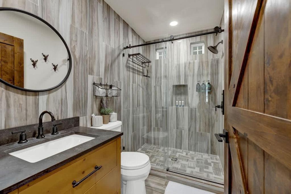 a bathroom with a shower and a toilet and a sink at Southern Charm - Near Main With Hot Tub in Fredericksburg
