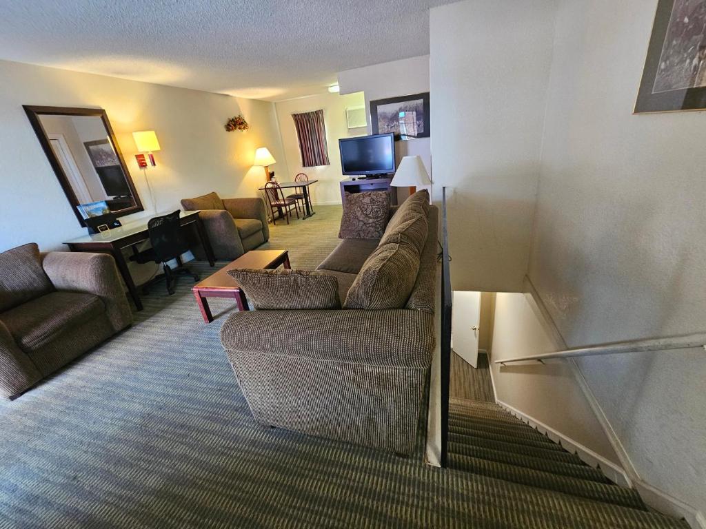 a living room with a couch and a table at Merrimac Inn and Suite in Williamsburg