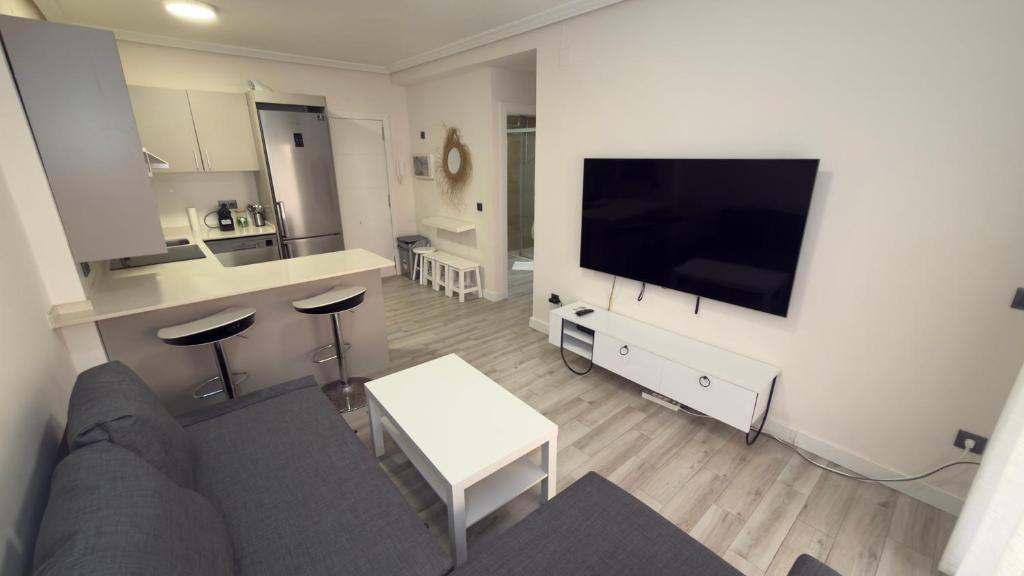 a living room with a couch and a flat screen tv at Turquesa 10 in La Pineda