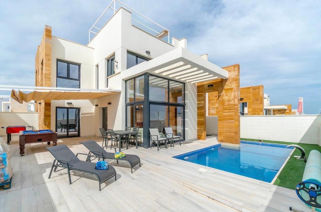 a villa with a swimming pool and a house at Casa Phillips in Orihuela Costa
