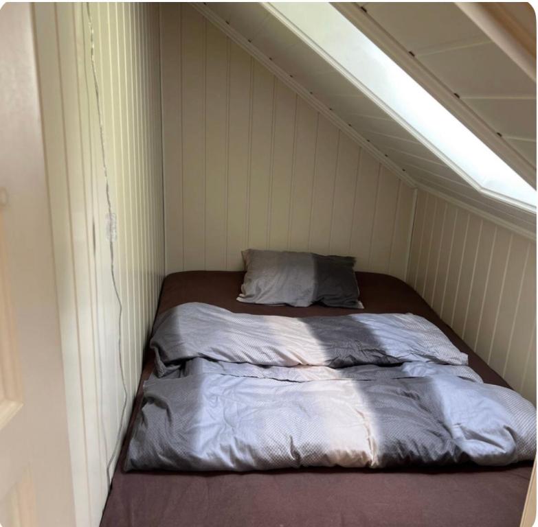 a bed in a small room with a ceiling at Marits residense in Kongsberg
