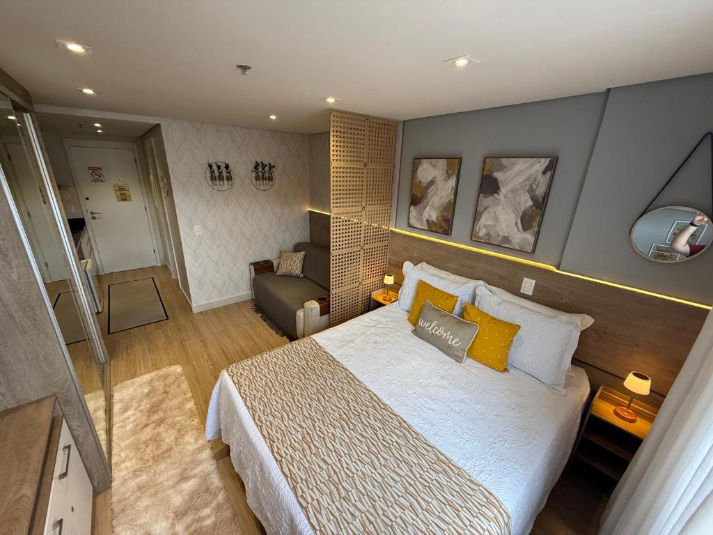 a bedroom with a large bed and a living room at Flat Completo Granja Brasil in Petrópolis