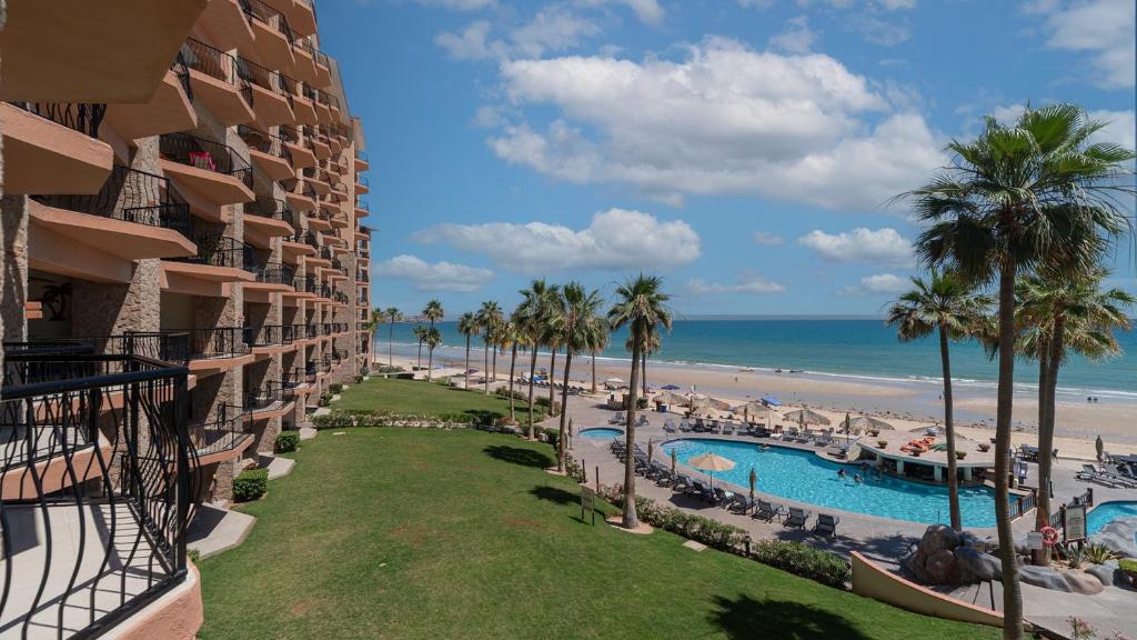 a view of the beach from the balcony of a resort at Laughing Seagull Lovely Oceanfront Condo in Puerto Peñasco