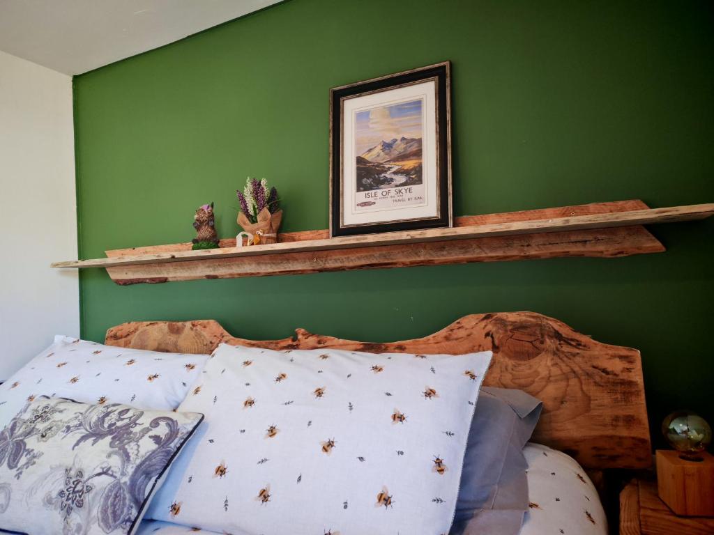 ein Schlafzimmer mit einer grünen Wand und einem Holzbett in der Unterkunft Wee Shot in Tain