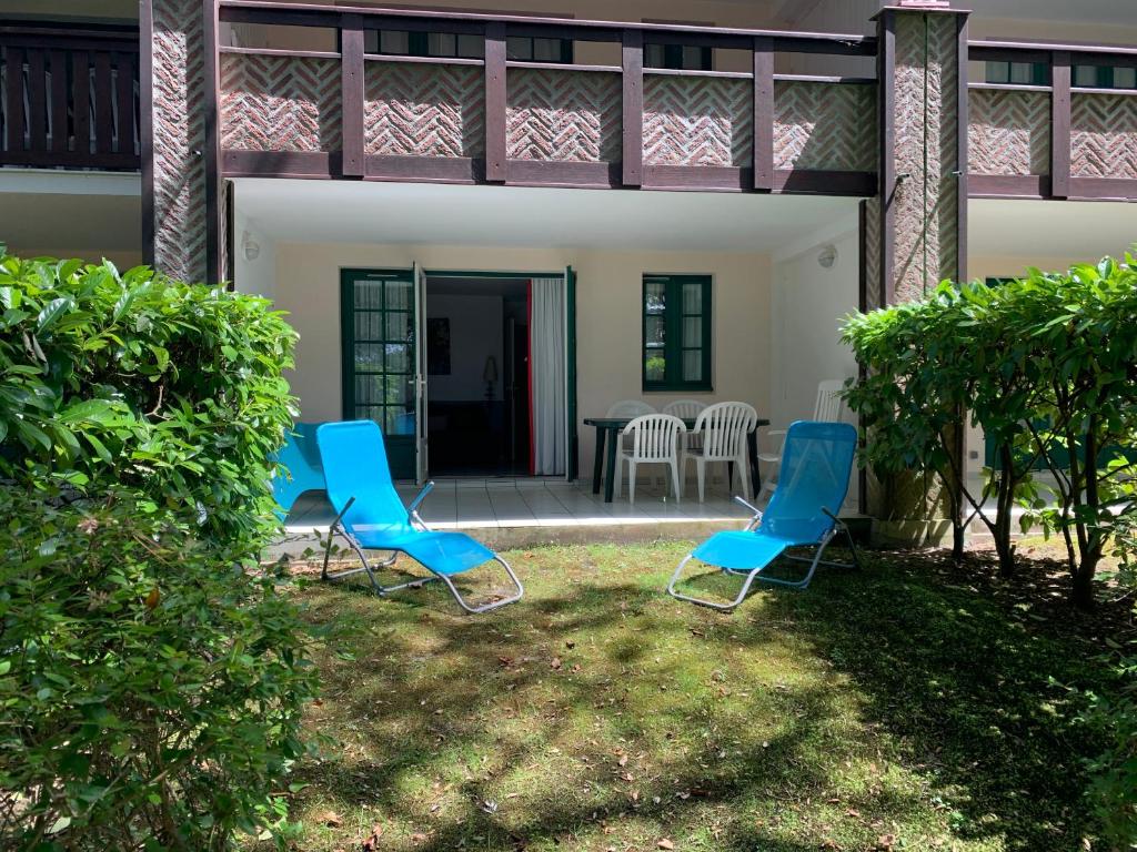 three blue chairs sitting in the yard of a house at L escale Oceane in Moliets-et-Maa
