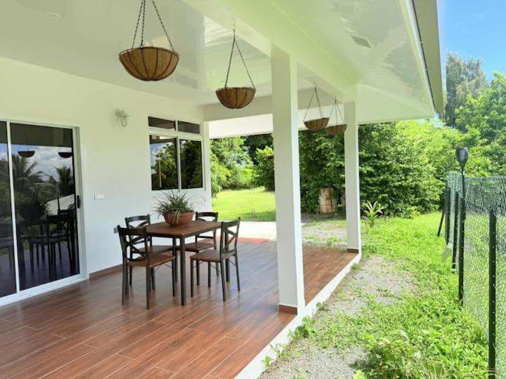 a porch with a wooden table and chairs on a house at Bungalow Miti in Uturoa
