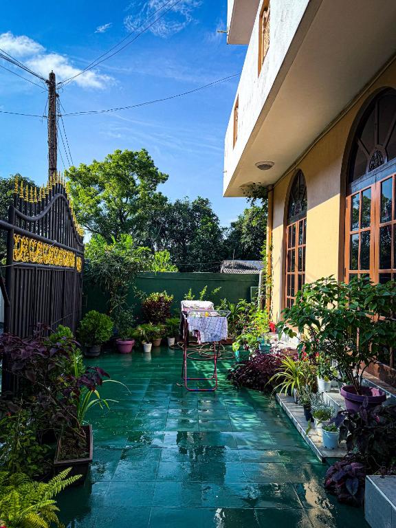 a patio with a table and potted plants next to a building at hostel of sincerity Female only in Maharagama