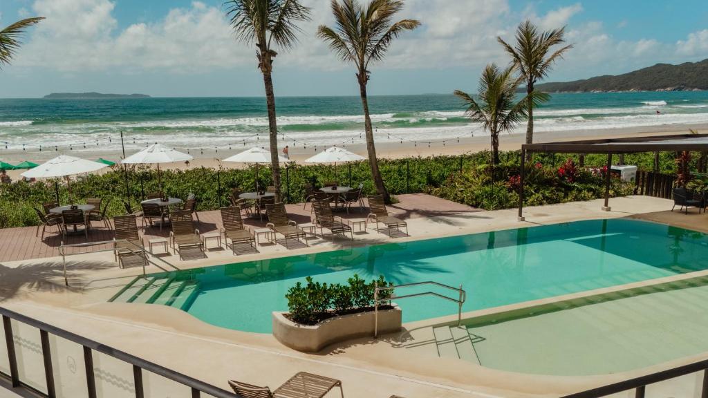 Blick auf einen Swimmingpool und den Strand in der Unterkunft Morada do Guaruçá in Bombinhas