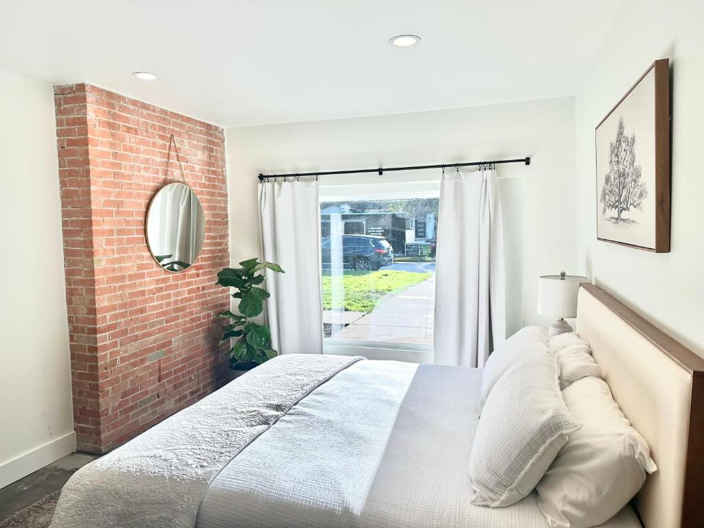 ein Schlafzimmer mit einem Bett und einer Ziegelwand in der Unterkunft Grapevine Studio in Grapevine