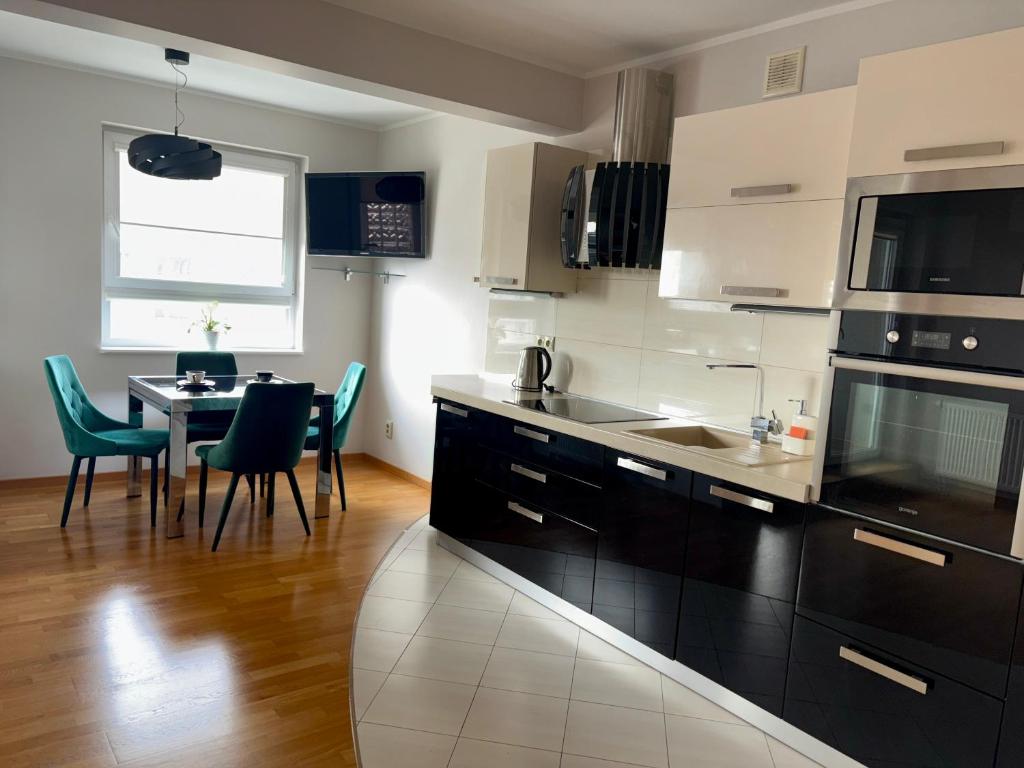 a kitchen with a sink and a table with chairs at STUDIO HETMANSKA H15 ElBląg in Elblag