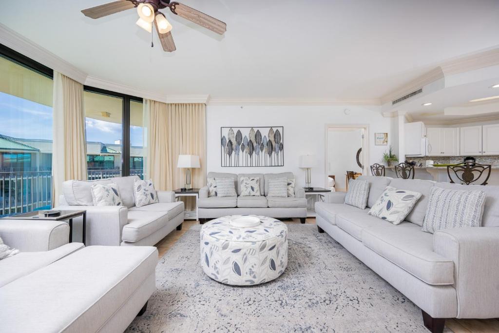 a living room with white couches and a table at Phoenix on the Bay 1524 in Orange Beach