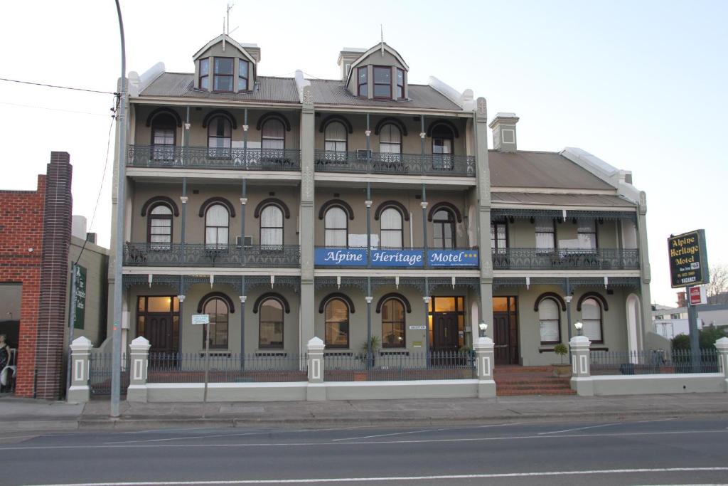 a large building on the corner of a street at Alpine Heritage Motel in Goulburn