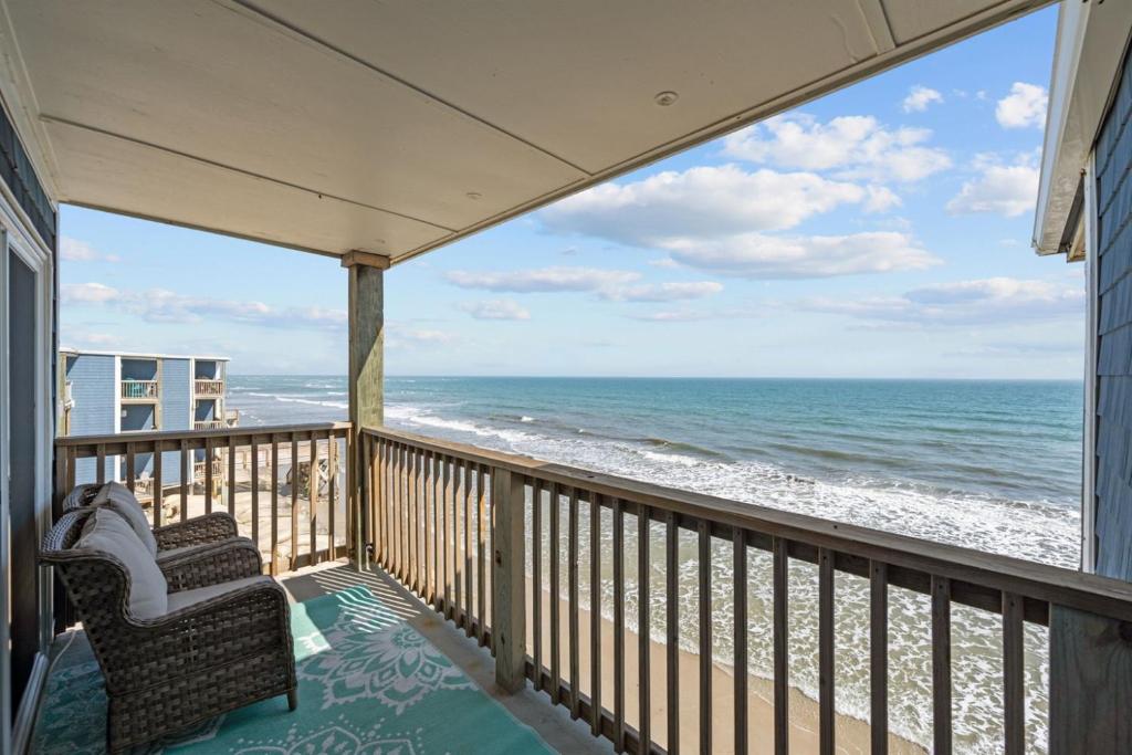 a balcony with two chairs looking out at the ocean at Beach, Please! Oceanfront, Balcony & Sunrise Views in North Topsail Beach