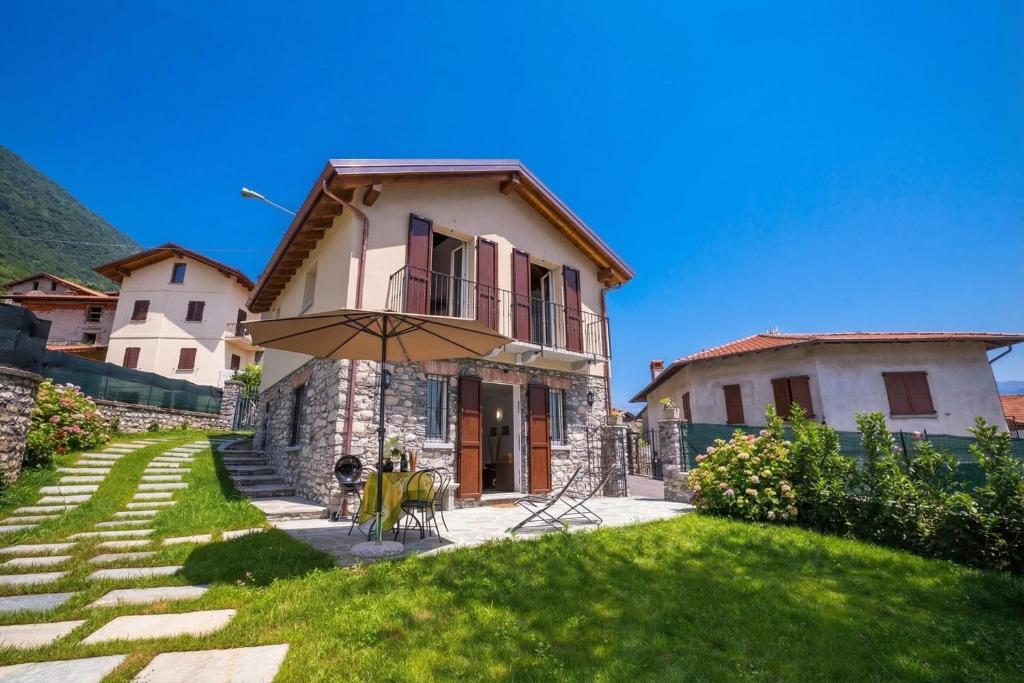 a house with an umbrella in the yard at Lenno Dolcelago in Lenno