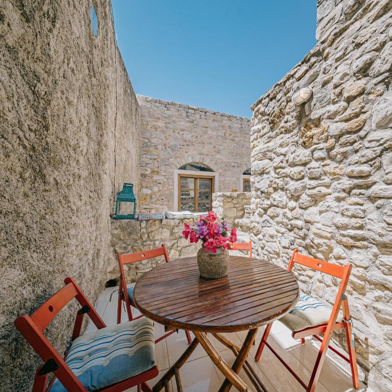 a patio with a wooden table and chairs at Alternative Medieval Villa in Kalamoti