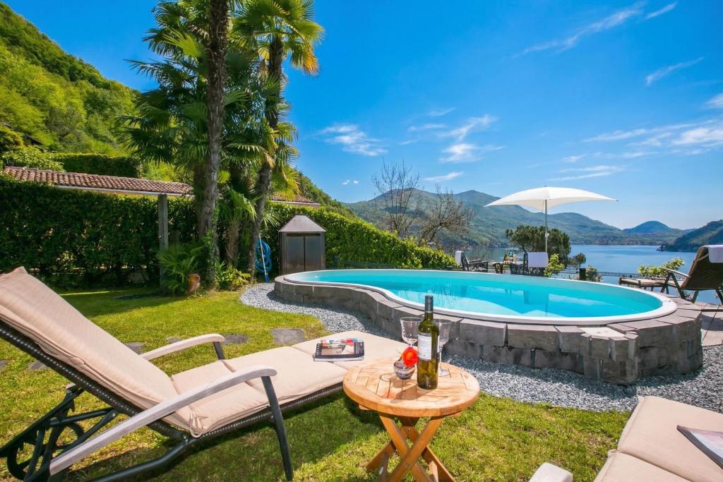 a backyard with a pool and a table with a bottle of wine at Morcote Magic View in Morcote