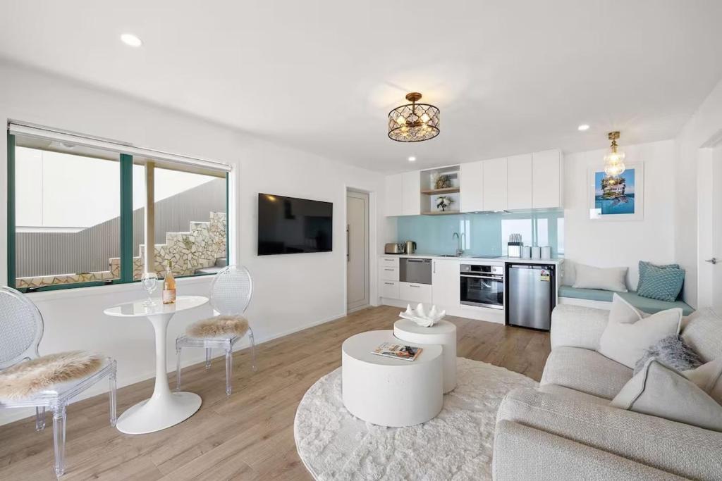 a living room with a couch and a table at Beachfront Studio - Ocean Views - Bell Block in New Plymouth
