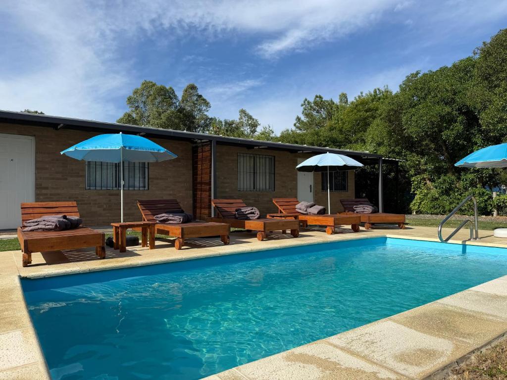 a swimming pool with patio furniture and umbrellas at Complejo San San Apto 201 in San Luis